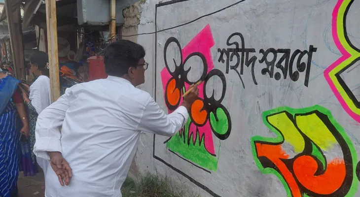 একুশে জুলাই ধর্মতলার শহিদ দিবসের সমর্থনে উলুবেড়িয়ার বাজার পাড়ায় দেওয়াল লিখছেন উলুবেড়িয়া পুরসভার চেয়ারম্যান অভয় দাস