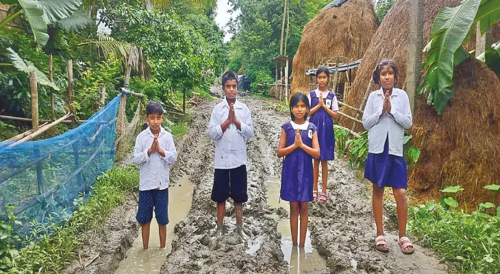কাদায় দাঁড়িয়ে রাস্তা পাকা করার আর্জি জানাল প্রাথমিক পড়ুয়ারা