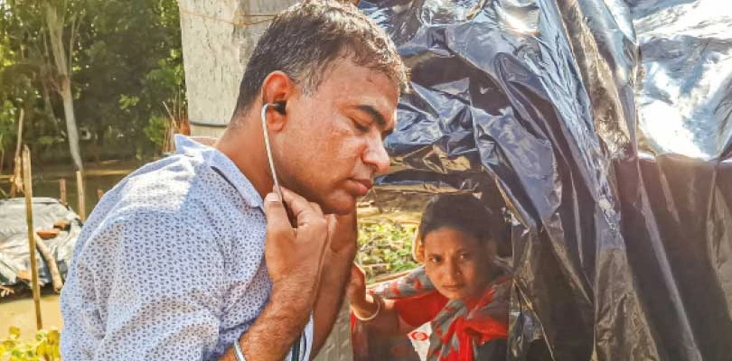 নৌকায় চেপে ভূতনির বানভাসিদের চিকিত্সা পরিষেবা দিচ্ছেন স্বাস্থ্যকর্তা